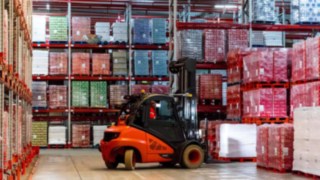 Stapler von Linde Material Handling beim Warenhandling im französischen Werk von Coca-Cola European Partners France Ein Stapler von Linde Material Handling nimmt im französischen Werk von Coca-Cola European Partners France Paletten mit Getränkekisten auf.