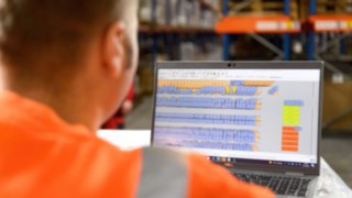 Mitarbeiter prüft den Lagerbestand vor dem Bildschirm