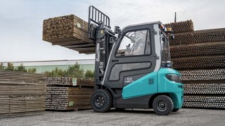 Baoli KBE 25 beim ablegen eines Bündel von Holzlatten in einer Leistenfabrik im Außengelände