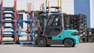 Baoli Dieselstapler KBD 25-35 in Fahrtrichtung links im Hintergrund Rungenpaletten 