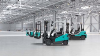 Baoli Gabelstapler Produktportfolio in Lagerhalle, Gabelstapler seitlich vorn, dahinter die Hubwagen 