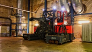 Votex Bison Elektro-Vierwege-Seitenstapler in einer dunklen Halle, leicht beleuchtet 