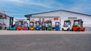 Mietstaplerflotte in einer Reihe vor dem LKW im Hintergrund, auf dem Betriebgelände