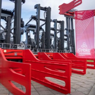 Drei Linde Gabelstapler mit Ballenklammer in rot als Anbaugerät in Reihe gestellt, rechts eine Fahne der Firma CABKA hängend am Anbaugerät angebracht