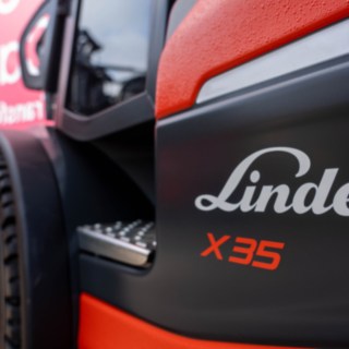 Nahaufname vom Linde X35 seitlich, nur der Einstieg und der Reifen sind zu sehen. Im Hintergrund die Fahne von CABKA.