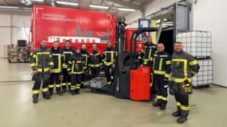 Gabelstapler führt mit Gabelzinken Fußball in ein Fußballtor