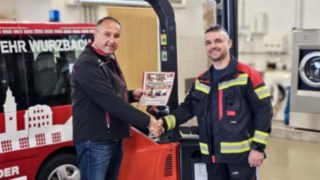 Geschäftsführer Renzo Müller links, Wehrführer Sandro Wildt rechts, mit Handschlag Übergabe Linde Hochhubwagen