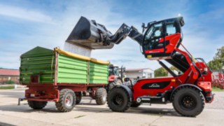 Im Praxistest der Linde YH60 Teleskoplader links bei Weizenverladung auf grünen Anhänger links 