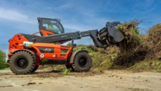 Roter Linde YH60 Teleskoplader links, der Grünschnitt mit der Schaufel aufnimmt 
