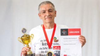 Ehrung des Jubiläumsteilnehmers 20 Jahre StaplerCup Portrait des Jubiläumsteilnehmers mit Pokal und Urkunde