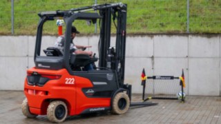 Staplerfahrer versucht einen Fußball in ein kleines Tor zu bekommen