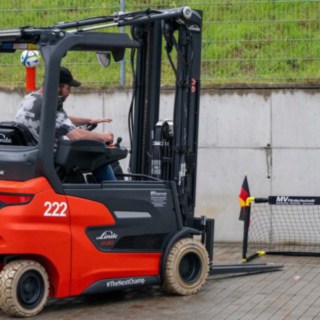 Staplerfahrer versucht einen Fußball in ein kleines Tor zu bekommen