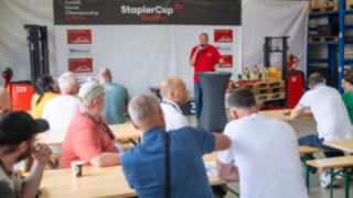 Alle Zuschauer und Staplerfahrer in einer Halle zur Siegerehrung 
