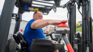 Staplerfahrer im Stapler drückt den Buzzer zum starten