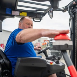 Staplerfahrer im Stapler drückt den Buzzer zum starten