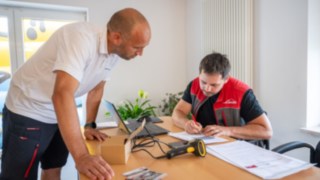 Staplerfahrer Prüft mit Fahrschullehrer die Fragen vom Prüfbogen der Theorieprüfung 