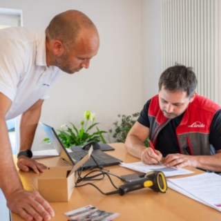 Staplerfahrer Prüft mit Fahrschullehrer die Fragen vom Prüfbogen der Theorieprüfung 