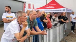 Alle Staperfahrer des Wettkampfes, stehem am Zaun und schauen der Einweisung zu