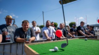 Golfschläger am Gabelstapler trifft mit Ball das Putt