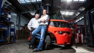 Geschäftsführer der MV Fördertechnik 2020 links Helmut Müller, daneben Sohn Renzo Müller an einem Linde H80 Stapler in der Lagerhalle