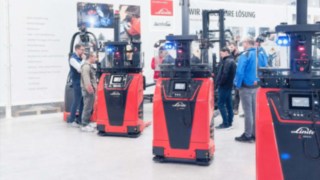 Drei Linde L-MATIC core Hochhubwagen auf einer Messe